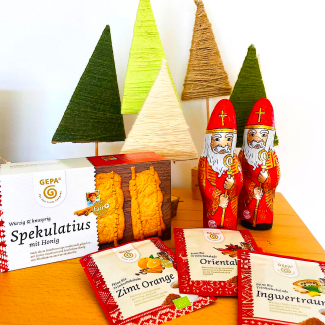 Zusammenstellung von Tannenbäumen aus gebasteltem Filz, Schoko-Nikolaus und Plätzchen